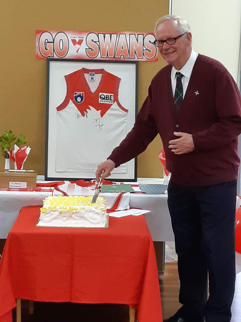 Fr Kevin cutting the cake